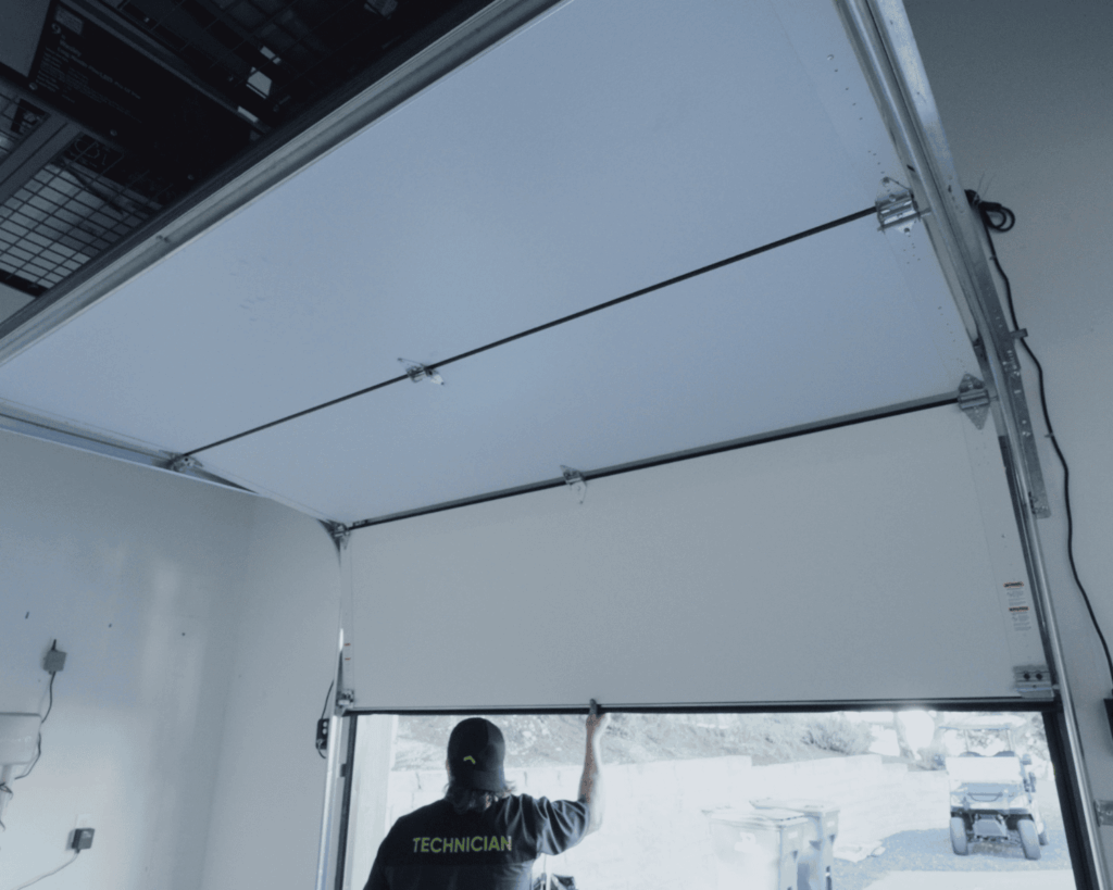 A professional Garage Up technician checking on the work of a garage repair job.