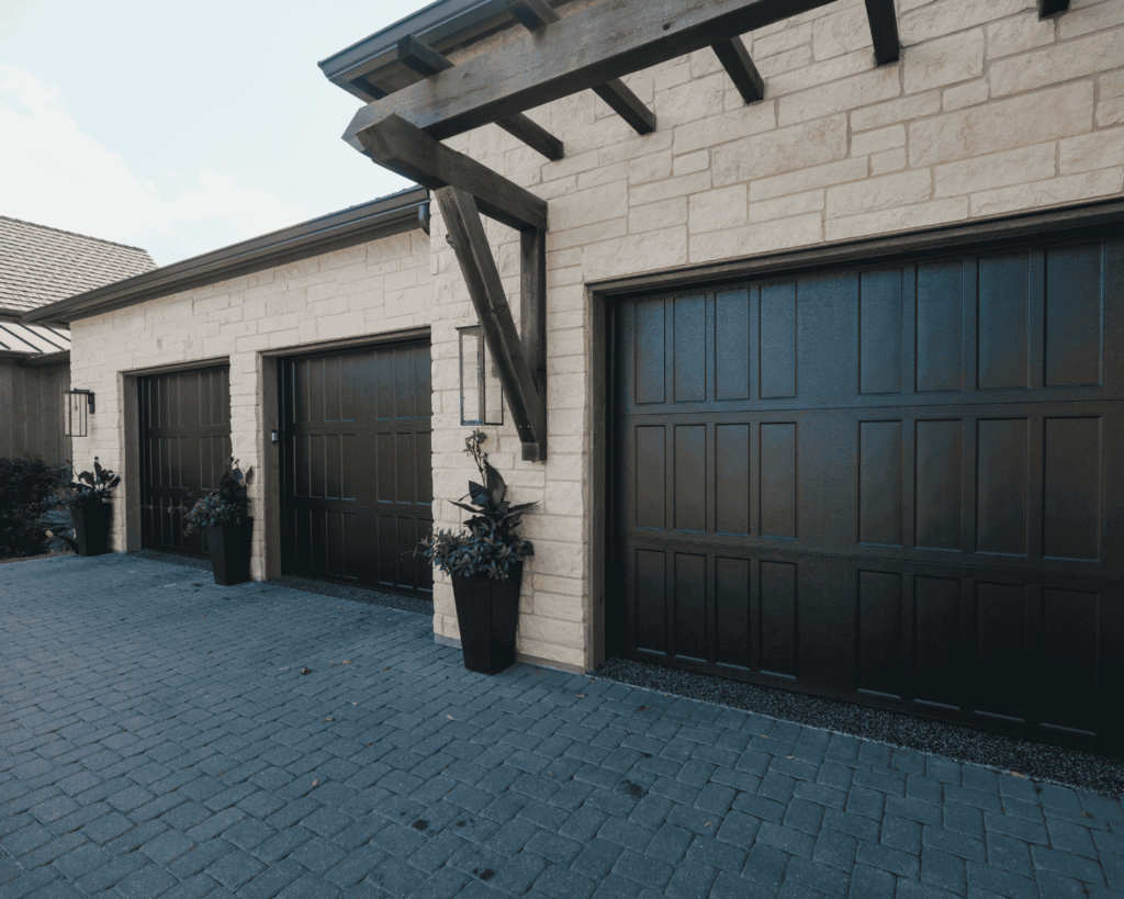 a three car garage with chocolate brown doors