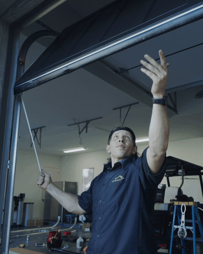 a Garage Up Austin technician adjusting a garage door