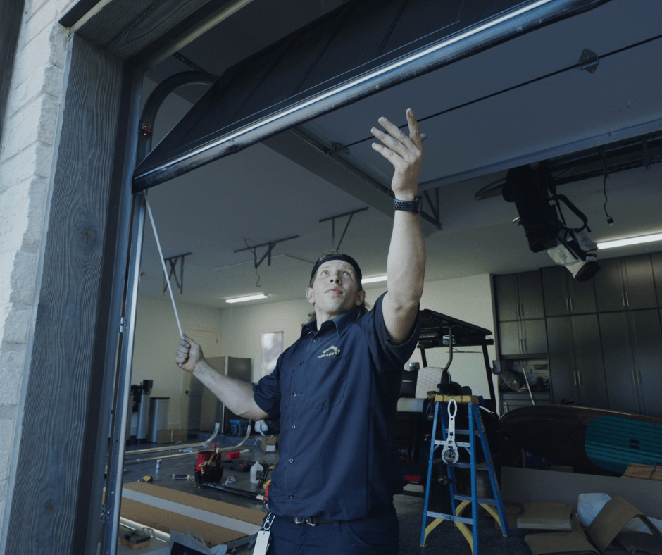 a Garage Up Austin technician adjusting a garage door. garage tune-up