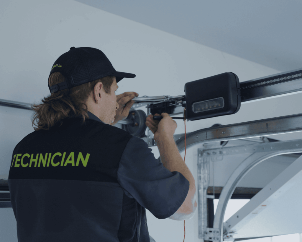 A technician installing a residential garage door lift_garage up