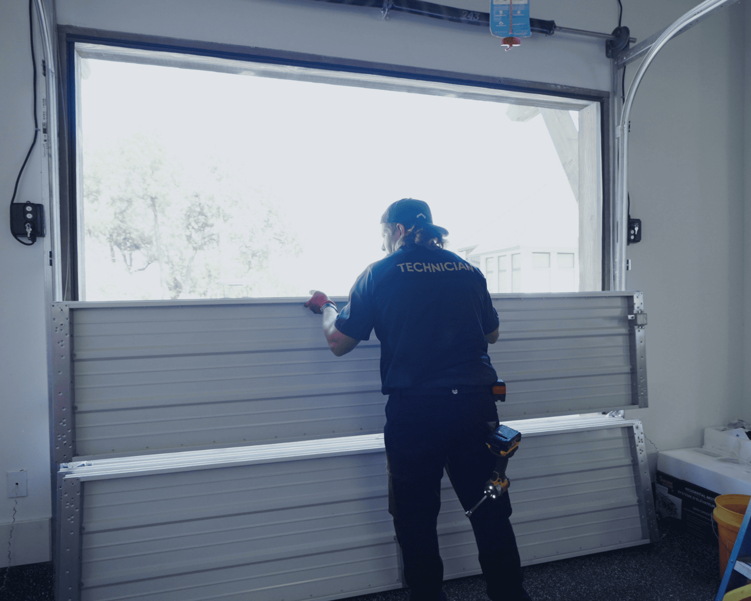 A professional technician replacing a garage door panel. Spring replacement.