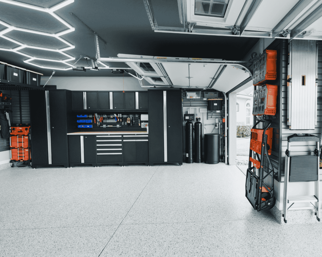 A newly renovated garage that includes new storage units, slat walls, and hex lights installed by professional technicians at Garage Up. garage lighting solutions