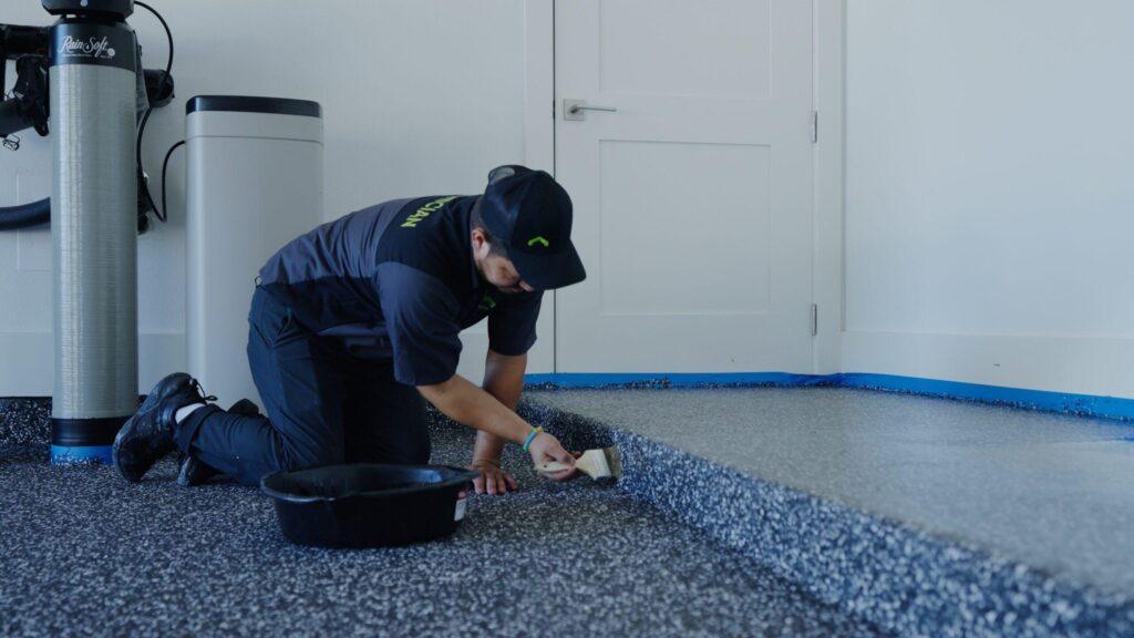 a garage up technician applying finishing touches to a newly installed epoxy floor
