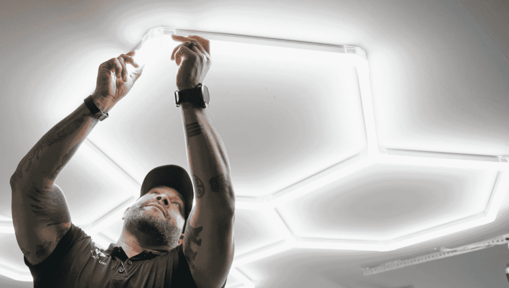 A professional Garage Up technician installing hex lights into a garage lighting upgrade project.