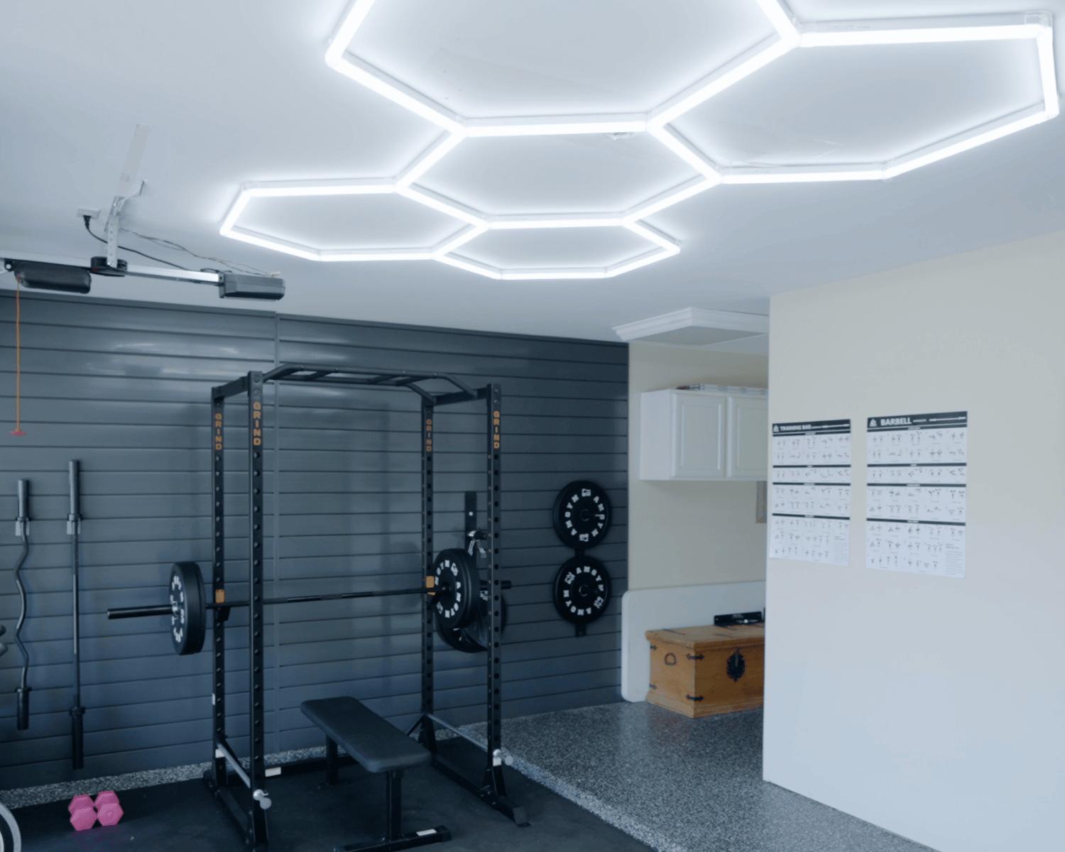 Hex lighting, epoxy flooring and wall paneling all put into place for the ultimate at-home gym. Gym Renovation.
