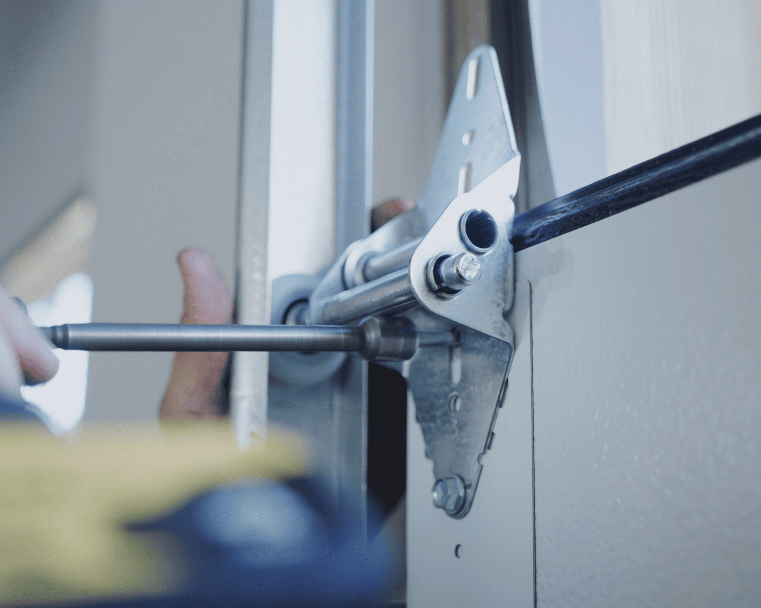 A professional technician adjusting the track of a new garage door. Garage door repair.