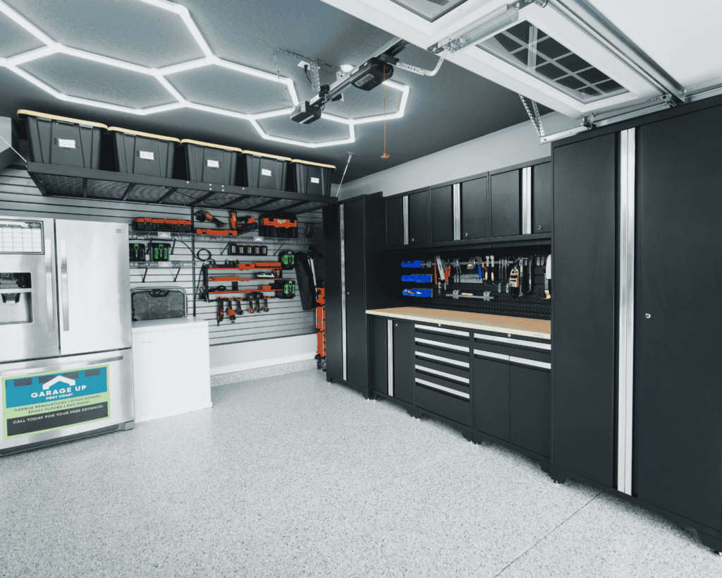 a renovated garage with storage solutions including new cabinets, overhead racks, and slat walls