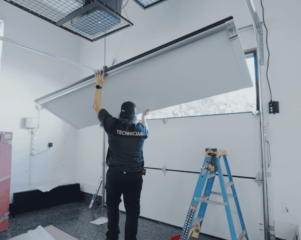 A professional technician replacing a garage door panel.