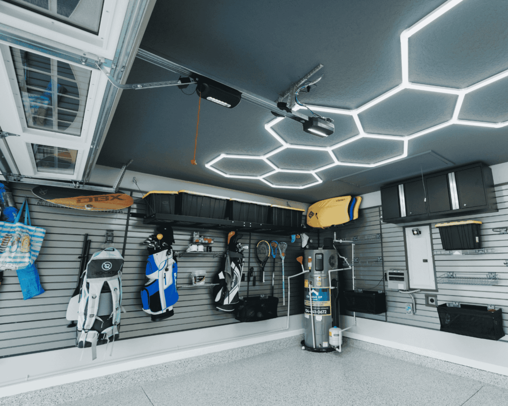 a newly renovated garage with slat walls on each wall storing numerous items on those wall and overhead storage.