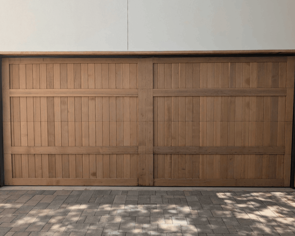 a newly installed wooden paneled garage door for a residential home-garage renovations in lakeway