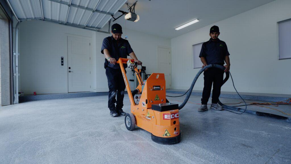 professional garage up technicians buffing a garage floor before installing epoxy flooring