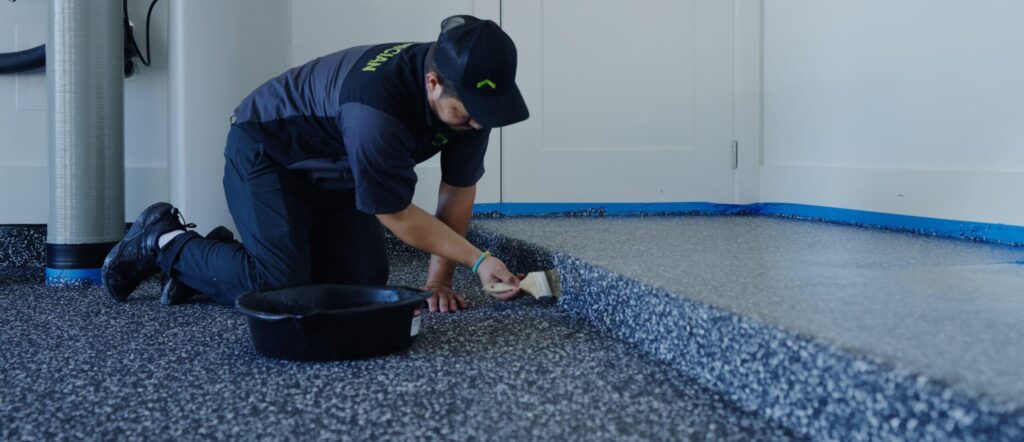 a garage up technician applying finishing touches to a newly installed epoxy floor