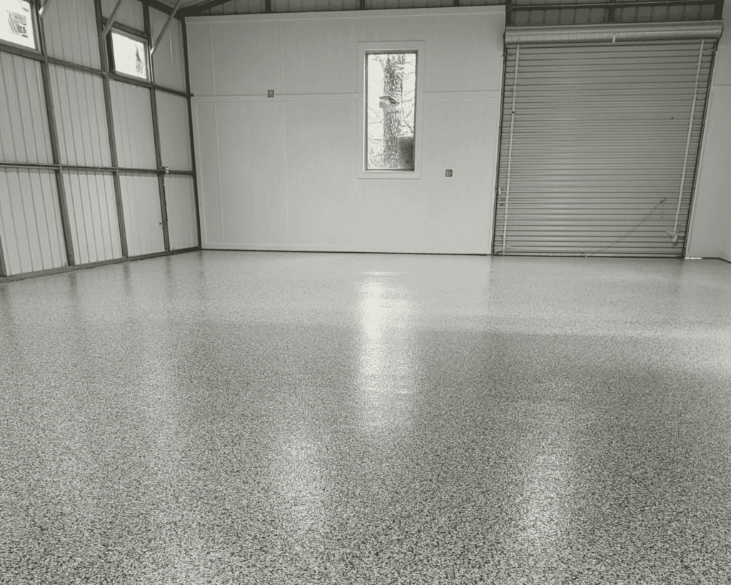 an industrial garage with a new titanium door and commercial flooring completed by technicians at garage up