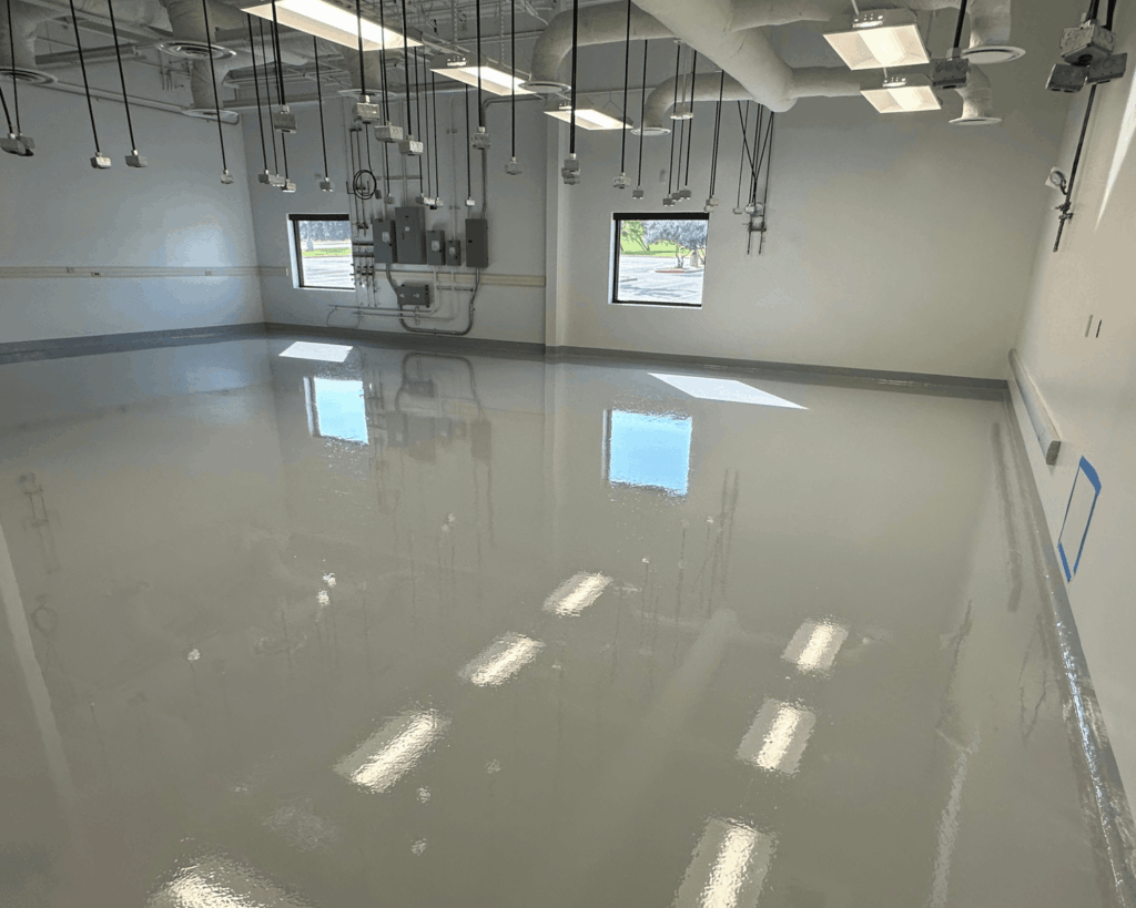 a freshly sealed light gray commercial flooring project in a warehouse