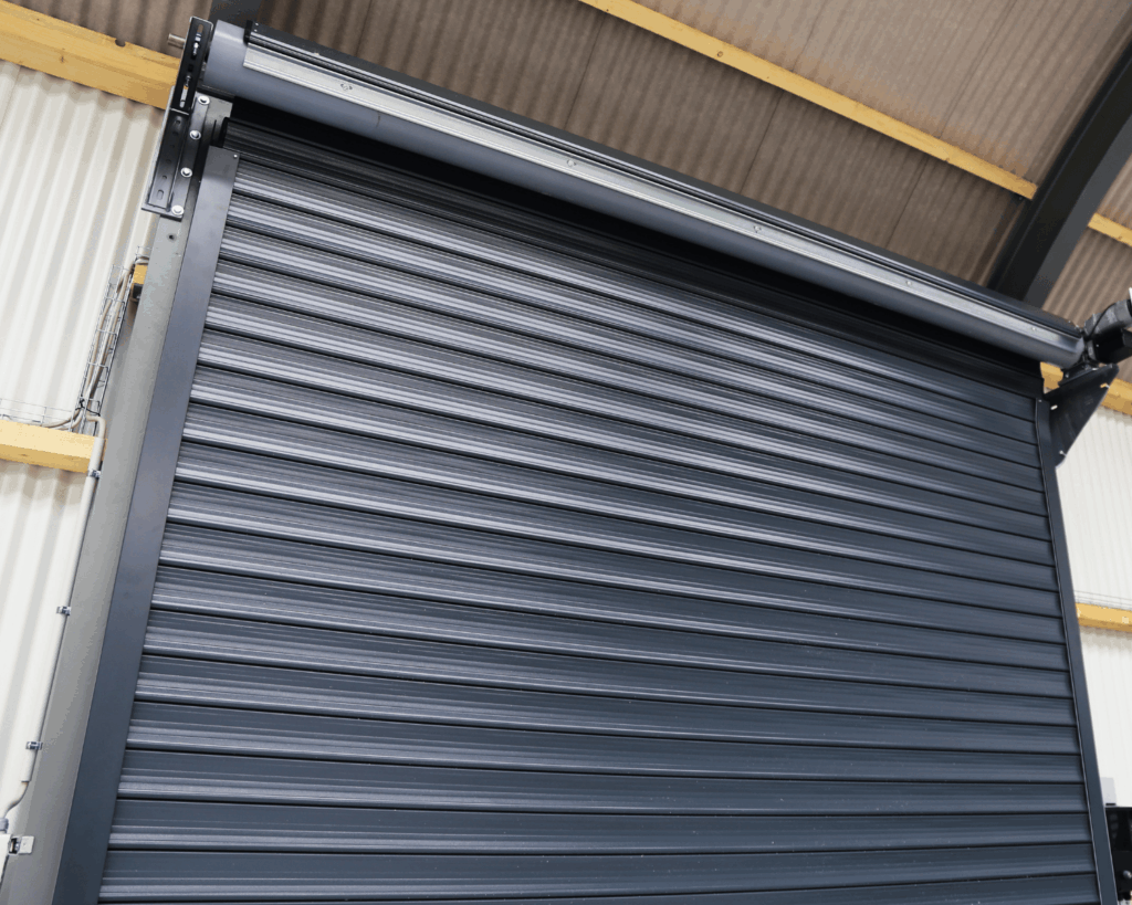 a tall steel commercial roll up door painted dark gray